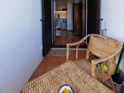 a wicker chair sitting in a room with a hallway at Akisol Albufeira Euphoria in Albufeira