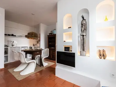 a dining room with white chairs and a table at Akisol Albufeira Euphoria in Albufeira