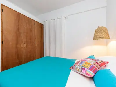 a bedroom with a blue bed and a wooden cabinet at Akisol Albufeira Euphoria in Albufeira