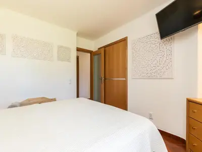 a bedroom with a white bed and a wooden cabinet at Akivillas Albufeira Felicity in Albufeira