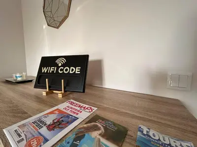 a table with a tv and some magazines on it at Falésia Beach Apartment in Albufeira