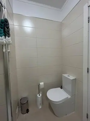 a white bathroom with a toilet and a shower at Falésia Beach Apartment in Albufeira