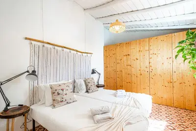 a bedroom with a white bed and a wooden wall at BeGuest Casa Romãzeira Typical Vila in Goncinha