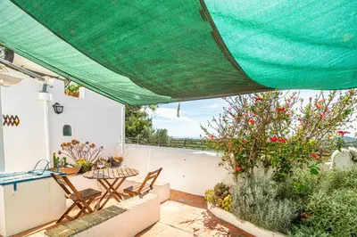 a patio with chairs and a green canopy at BeGuest Casa Romãzeira Typical Vila in Goncinha