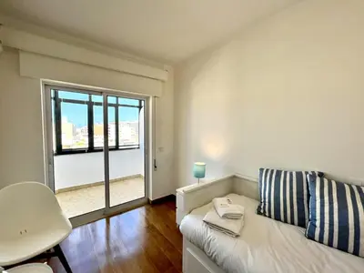 a living room with a white couch and a window at Faro Rising by Homing in Faro
