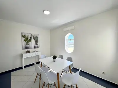 a dining room with a white table and chairs at Faro Rising by Homing in Faro
