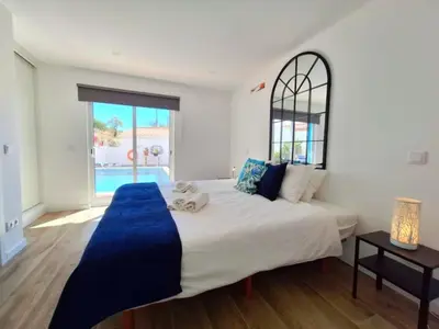 a bedroom with a large bed and a large window at Vila Arvela in Albufeira