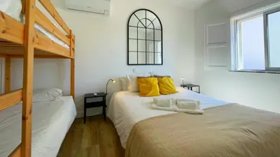 a bedroom with two beds with yellow pillows at Vila Arvela in Albufeira