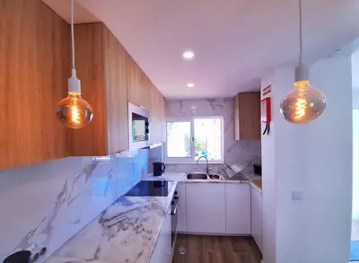 a kitchen with marble counter tops and wooden cabinets at Vila Arvela in Albufeira