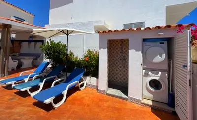 a group of chairs and a washing machine on a patio at Vila Arvela in Albufeira
