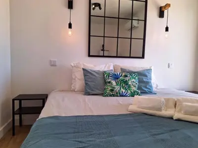 a large bed with pillows and a mirror on the wall at Vila Arvela in Albufeira