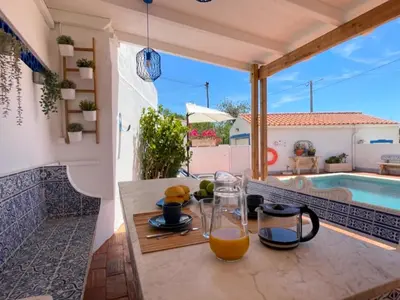 a table with a glass of orange juice on a patio at Vila Arvela in Albufeira