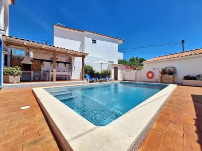 a swimming pool in the backyard of a house at Vila Arvela in Albufeira