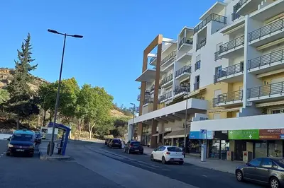 a street with cars parked in front of a building at The Best Downtown Albufeira in Albufeira