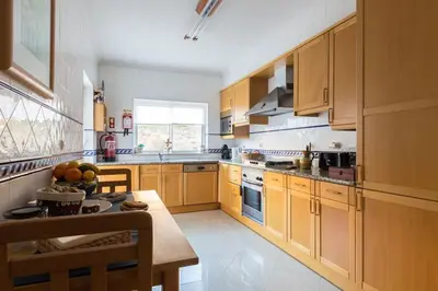 a kitchen with wooden cabinets and a table with fruit on it at The Best Downtown Albufeira in Albufeira