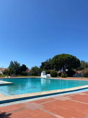 a large swimming pool with blue water at Cozy Albufeira Charm in Albufeira
