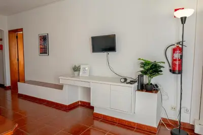 a room with a fireplace with a tv on a wall at Cozy Albufeira Charm in Albufeira