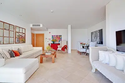 a living room with white couches and a dining room at News Apartment in Vilamoura