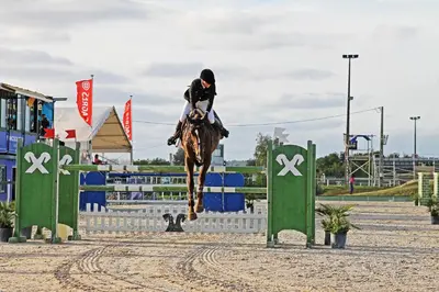 a person riding a horse jumping over an obstacle at News Apartment in Vilamoura