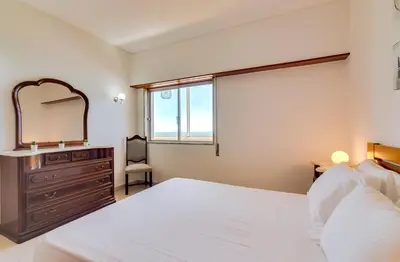 a bedroom with a bed and a dresser and a mirror at AL - Apartamento Portas do Mar in Quarteira