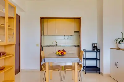 a kitchen with a table with a bowl of fruit on it at AL - Apartamento Portas do Mar in Quarteira