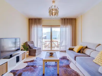 a living room with a couch and a tv and a table at AL - Apartamento Falésia Flat in Vilamoura