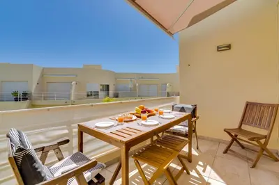 a patio with a table and chairs on a balcony at AL - Apartamento Falésia Flat in Vilamoura