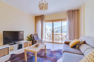 a living room with a couch and a tv at AL - Apartamento Falésia Flat in Vilamoura