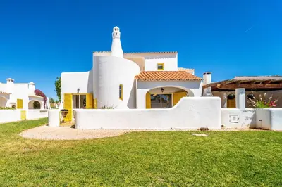 a large white house with a white tower at Villa Bougainvilla - Vilamoura - Pool - Free wifi - Air con in Quarteira