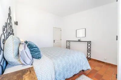a bedroom with a bed with a blue comforter at Villa Bougainvilla - Vilamoura - Pool - Free wifi - Air con in Quarteira