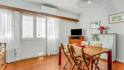 a dining room with a table and chairs and a television at Vilamoura Coastal Retreat by LovelyStay in Vilamoura
