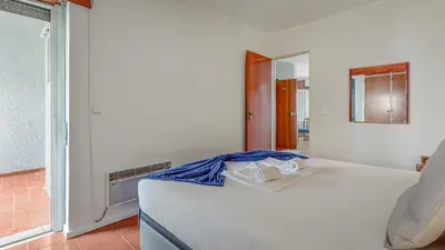 a bedroom with a white bed and a window at Vilamoura Coastal Retreat by LovelyStay in Vilamoura
