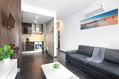 a living room with a couch and a kitchen at Apartamento Oceano in Albufeira