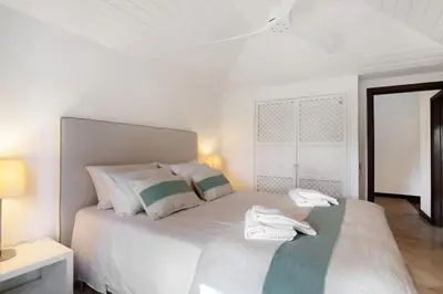 a white bedroom with a bed with two towels on it at Vilamoura com Piscina e Wifi in Vilamoura