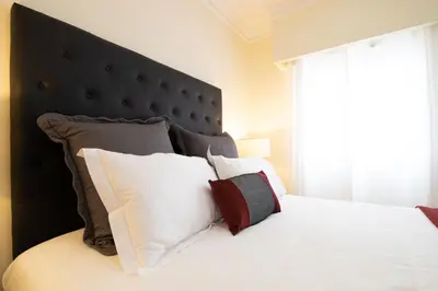 a bedroom with a bed with a black headboard and pillows at Sunny, The House - AL in Faro