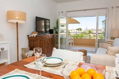 a dining room with a table with a view of the living room at Barracuda A14 in Albufeira