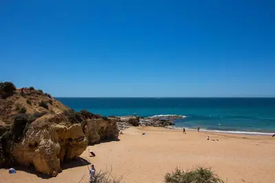 a beach with people on the sand and the ocean at Barracuda A14 in Albufeira