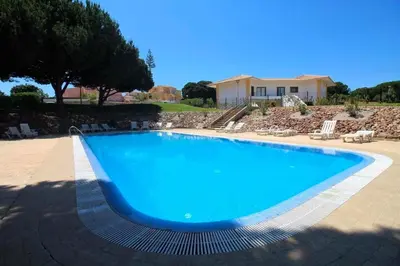 a large blue swimming pool in front of a house at Casa Relax à Olhos Albufeira in Albufeira