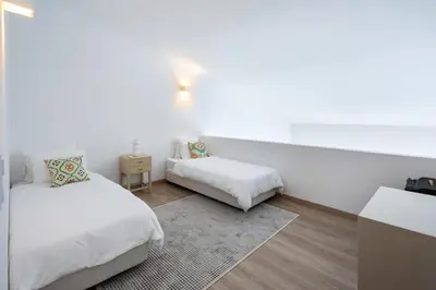 a white room with two beds and a table at Casa Relax à Olhos Albufeira in Albufeira
