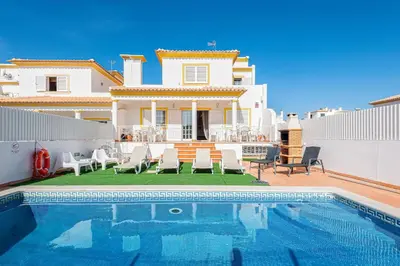 a villa with a swimming pool in front of a house at JUDY - Albufeira in Albufeira