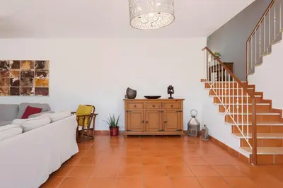 a living room with a couch and a staircase at JUDY - Albufeira in Albufeira