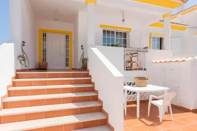 a staircase in a house with a table and a table at JUDY - Albufeira in Albufeira