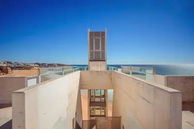a building on the beach with the ocean in the background at Albufeira Old Town Center - VERASOL 1 in Albufeira