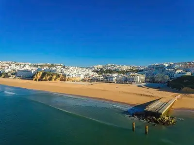 a view of a beach with a city in the background at Albufeira Old Town Center - VERASOL 1 in Albufeira
