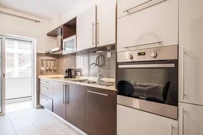 a kitchen with brown cabinets and a stainless steel oven at Albufeira, OLD TOWN - VERASOL N in Albufeira