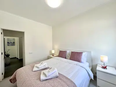 a bedroom with a large bed with towels on it at Quarteira Ocean Breeze 1 With Pool by Homing in Quarteira