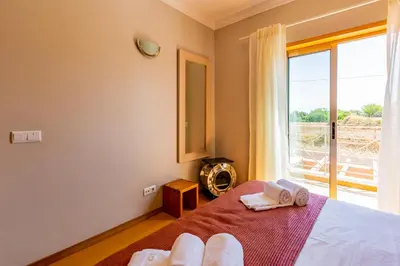 a bedroom with a bed and a large window at Casa Colina 2 in Albufeira