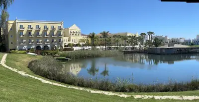 a body of water next to a large building at Vilamoura Marina Lake in Vilamoura
