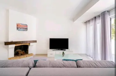 a living room with a couch and a flat screen tv at Marina Holiday House in Quarteira