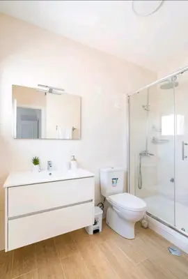 a bathroom with a toilet and a sink and a shower at Marina Holiday House in Quarteira